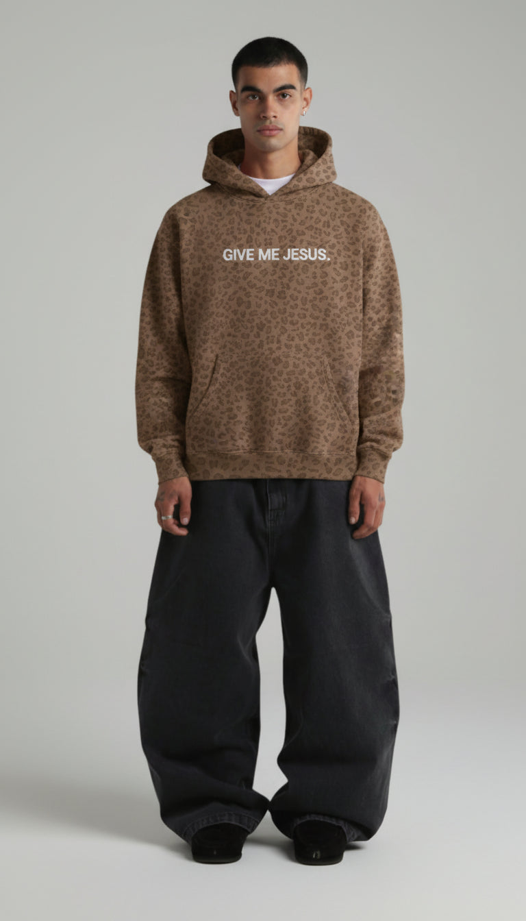 Man wearing a brown hoodie with 'Give Me Jesus' text on a plain background