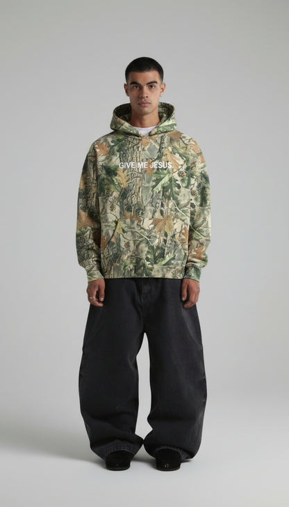 Person wearing a camouflage hoodie with text on a plain background